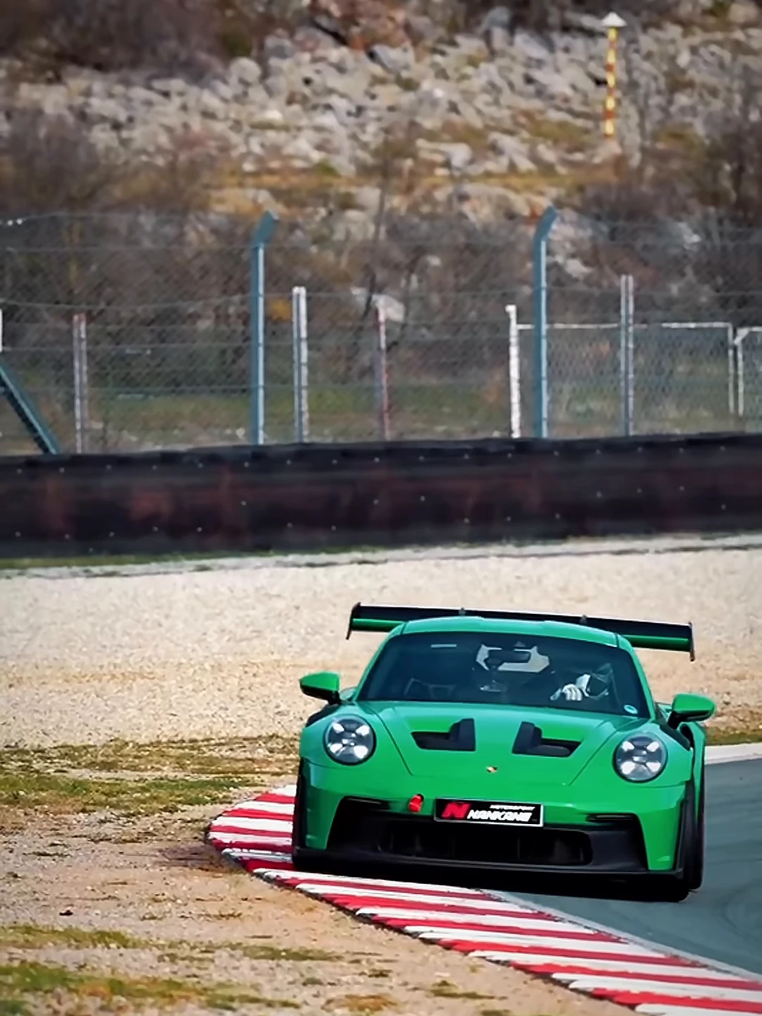 Porsche 911 GT3 verde trazando una curva en circuito