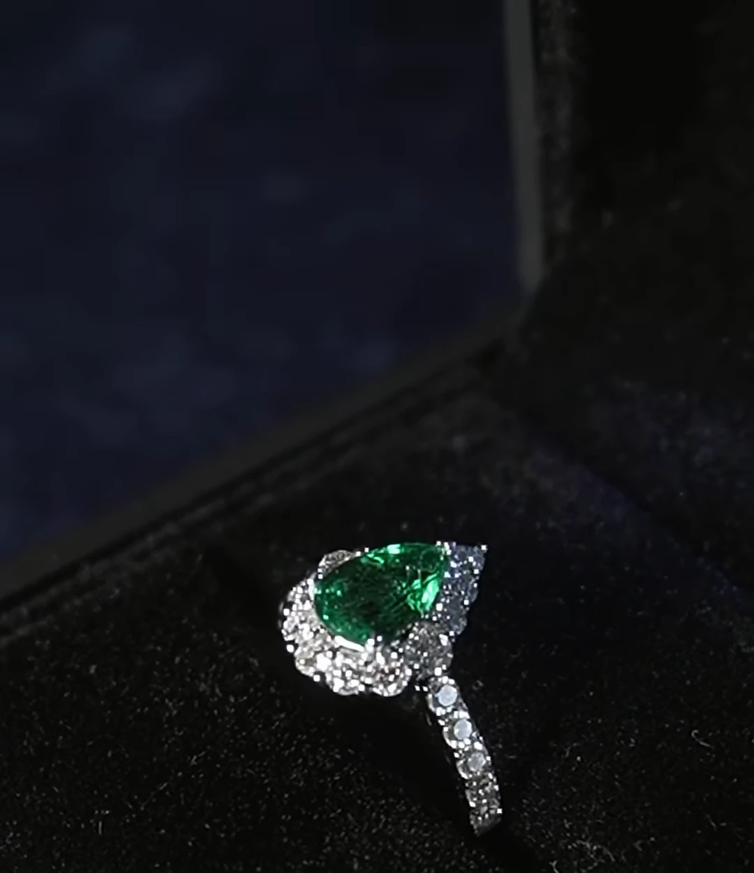 Anillo de esmeralda y diamantes sobre terciopelo negro