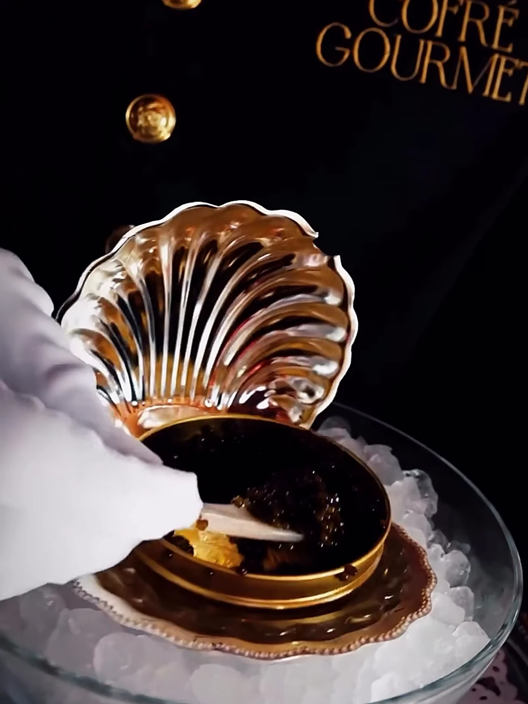 Servicio de caviar en una concha dorada, con guante blanco