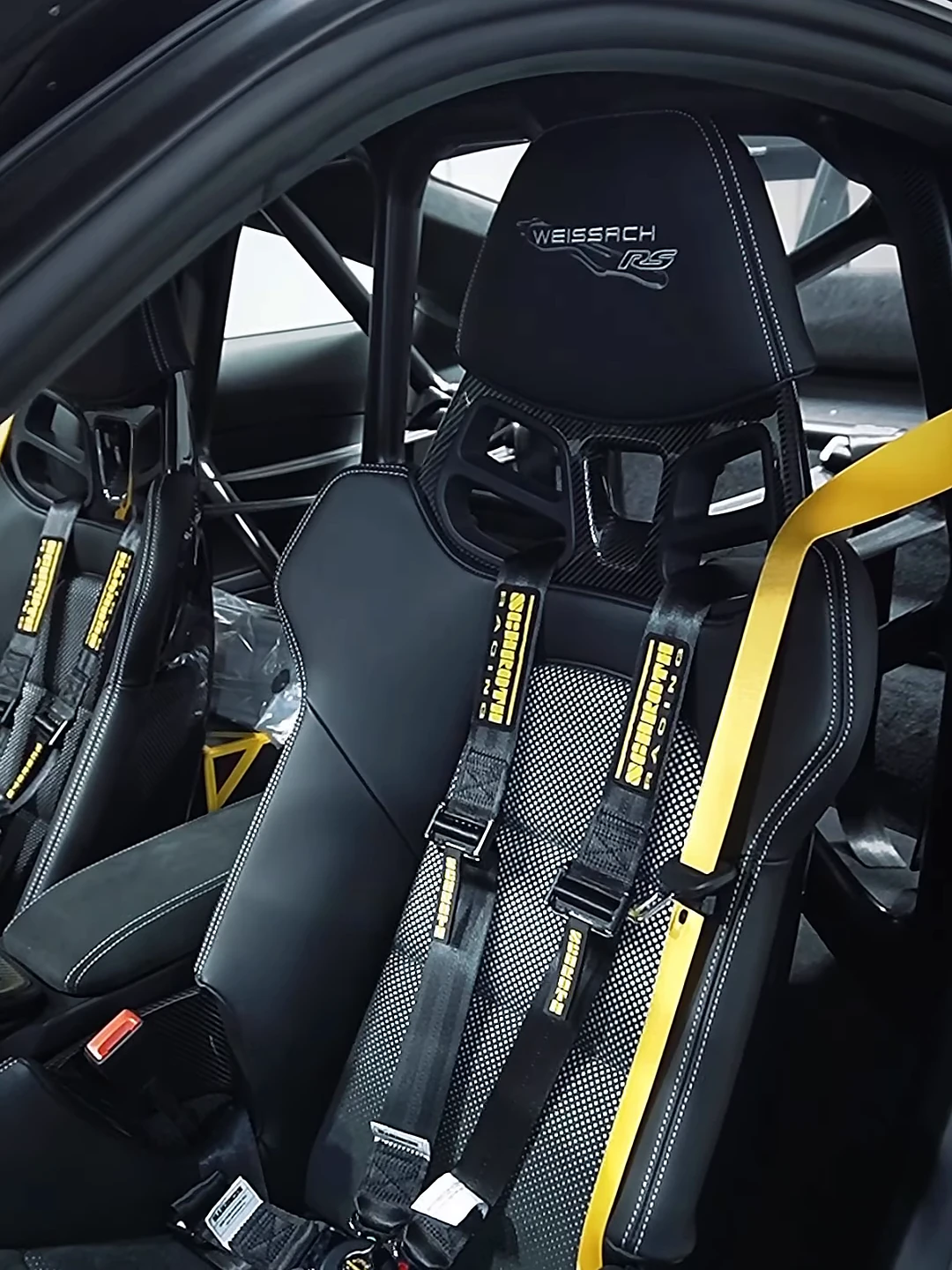 Asientos de competición con cinturones amarillos de un GT3 RS de TN Autosport